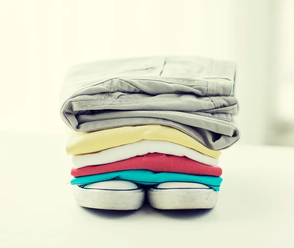Close up of folded shirts and boots on table — Stock Photo, Image