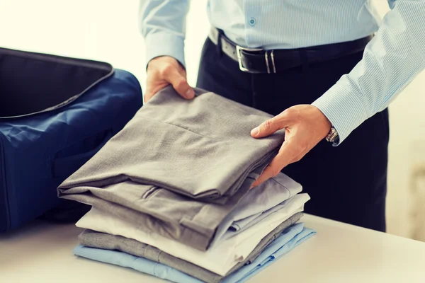 Geschäftsmann packt Kleidung in Reisetasche — Stockfoto