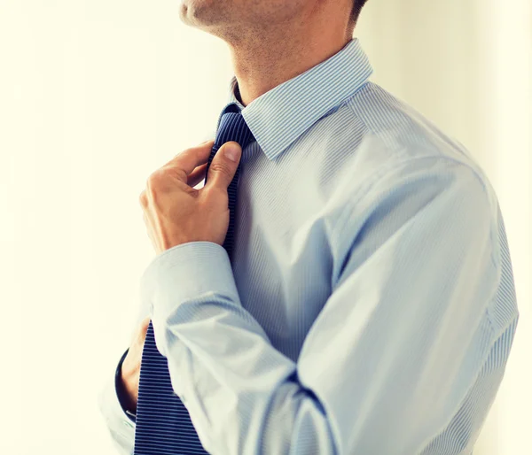 Close up of man in shirt adjusting tie on neck — Stock Photo, Image