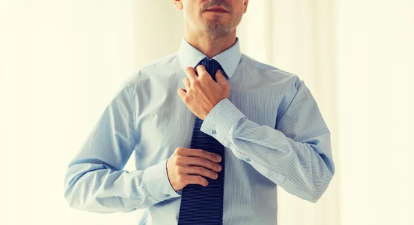 Close up of man in shirt adjusting tie on neck — Stok Foto
