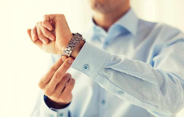 Close-up van de mens in shirt bevestiging polshorloge — Stockfoto