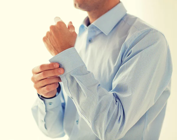 Bliska człowieka mocowania przycisków na rękaw koszuli — Zdjęcie stockowe