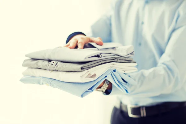 Крупним планом бізнесмен тримає складені сорочки — стокове фото