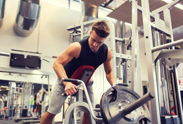 Young man exercising on t-bar row machine in gym — Stock Photo, Image