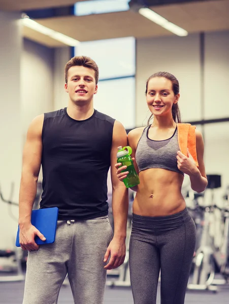 Glückliches Paar im Fitnessstudio mit Wasser und Tablet-PC — Stockfoto