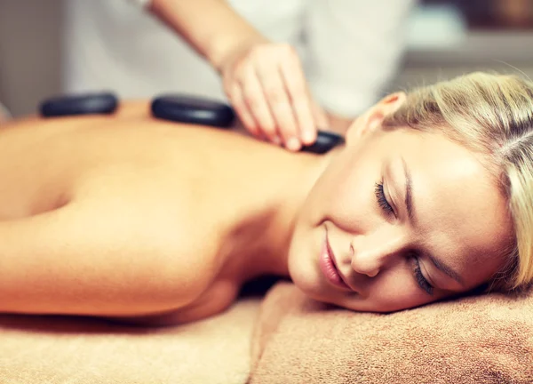 Zamknij się z kobieta o masaż gorącymi kamieniami w spa — Zdjęcie stockowe