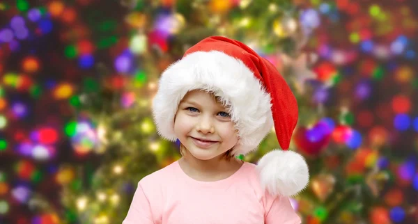 Lächelndes kleines Mädchen mit Weihnachtsmütze zu Hause — Stockfoto