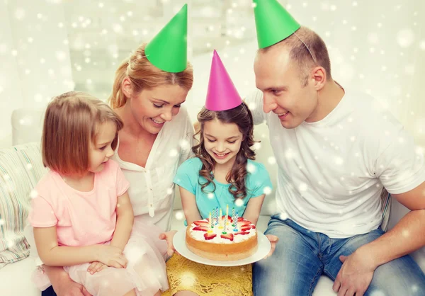 Gelukkig gezin met twee kinderen in feestmutsen thuis — Stockfoto