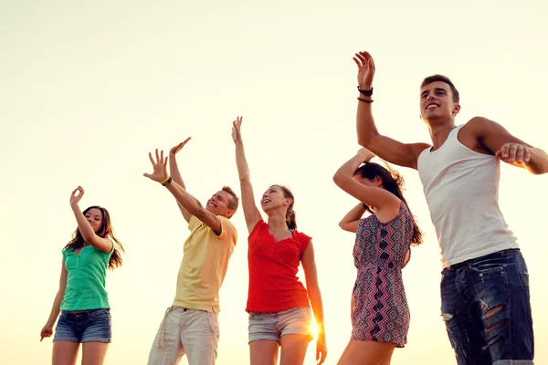 Smiling friends dancing on summer beach — Stock Photo, Image