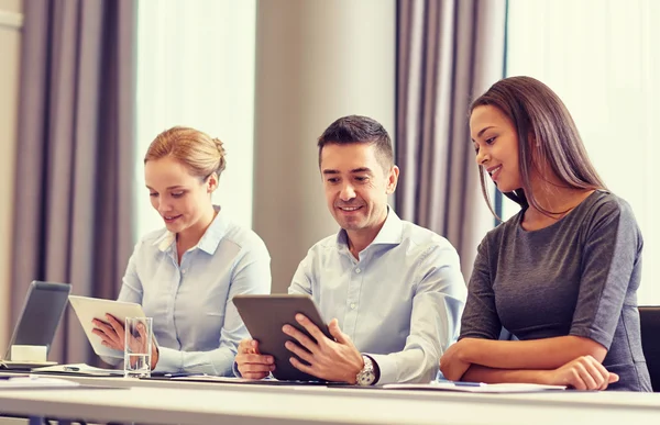 Uomini d'affari sorridenti con tablet pc in ufficio — Foto Stock