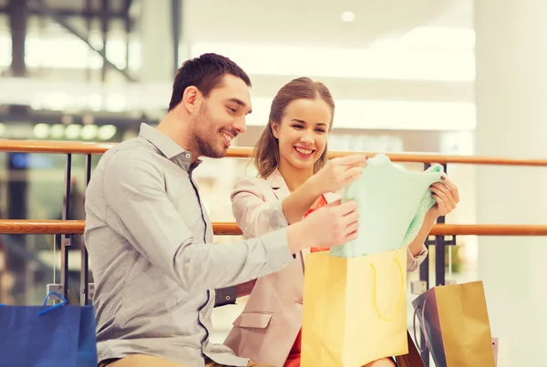 Gelukkig jong paar met boodschappentassen in winkelcentrum — Stockfoto
