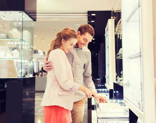 Happy couple choosing engagement ring in mall — Stock Photo, Image