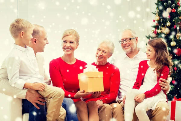 Família sorridente com presente em casa — Fotografia de Stock