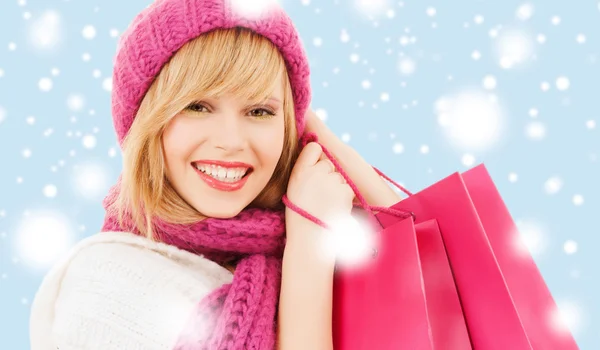 Mulher de chapéu rosa e cachecol com sacos de compras — Fotografia de Stock