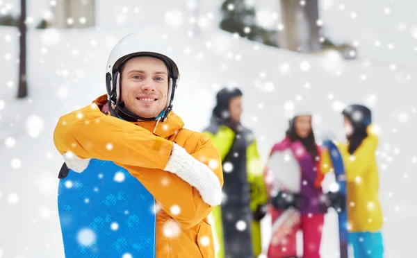 Happy friends in helmets with snowboards — Stock Photo, Image