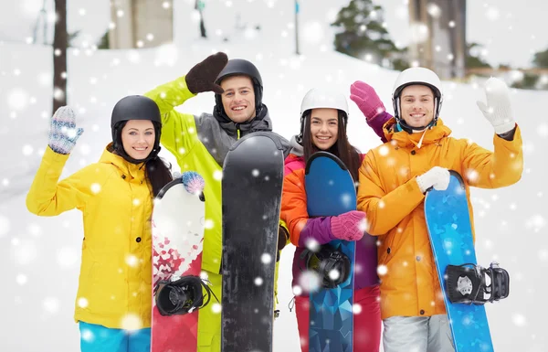 Gelukkige vrienden in helmen met snowboards — Stockfoto