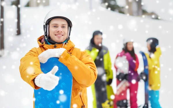 Happy young man with snowboard showing thumbs up — Stock Photo, Image