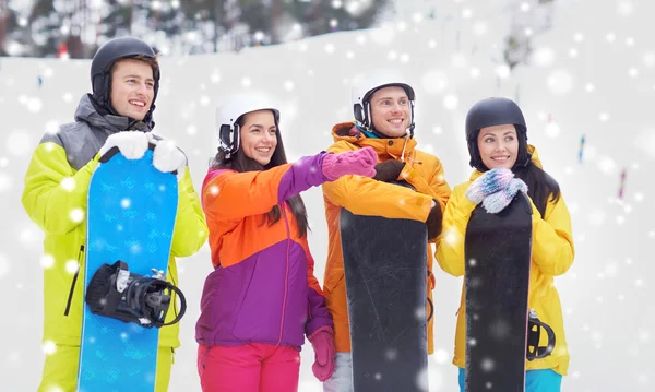 Glückliche Freunde in Helmen mit Snowboards — Stockfoto