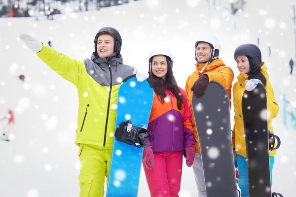 Gelukkige vrienden in helmen met snowboards — Stockfoto