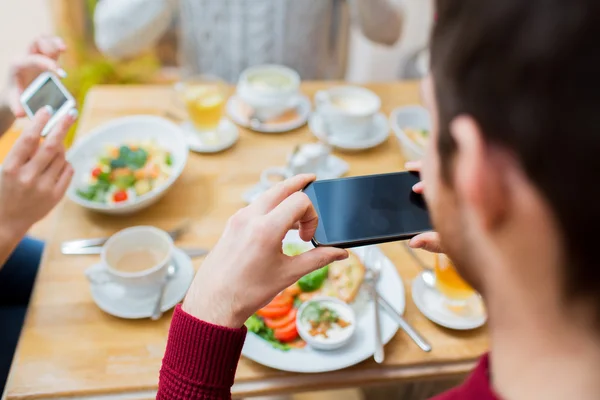 Amigos com smartphones tirando fotos de alimentos — Fotografia de Stock