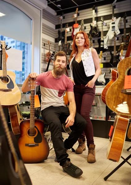 Par de músicos com guitarra na loja de música — Fotografia de Stock