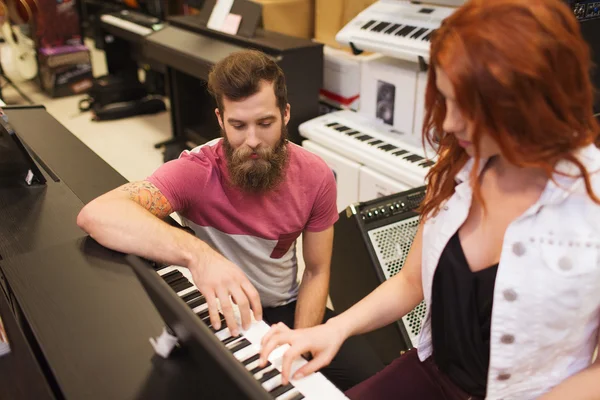 Homem e mulher tocando piano na loja de música — Fotografia de Stock