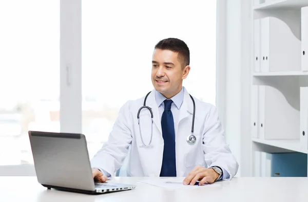 医療事務のラップトップで笑顔の男性医師 — ストック写真