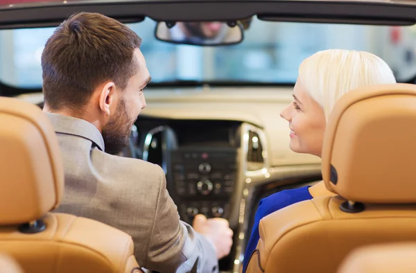Šťastný pár sedící v autě na autosalonu nebo salonu — Stock fotografie