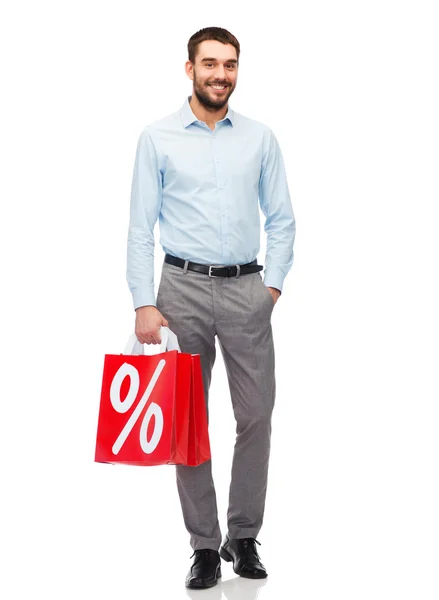 Hombre sonriente con bolsa de compras roja — Foto de Stock
