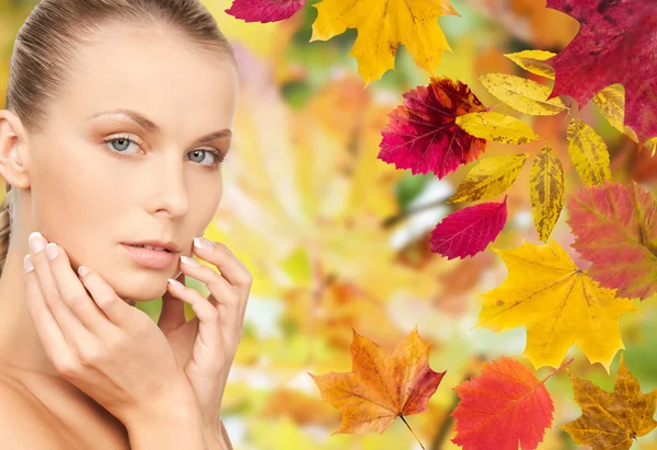 Beautiful woman touching her face over autumn Stok Resim