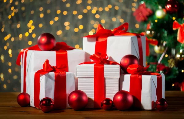 Geschenkboxen und rote Kugeln unter dem Weihnachtsbaum — Stockfoto