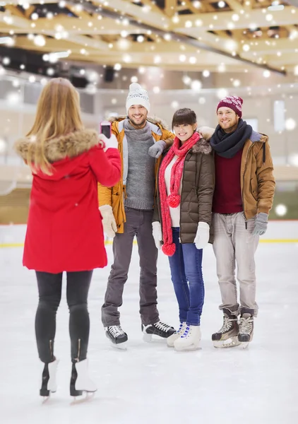 Amigos felices tomando fotos en pista de patinaje — Foto de Stock