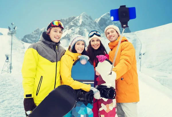 Szczęśliwy przyjaciół z deski snowboardowe i smartphone — Zdjęcie stockowe