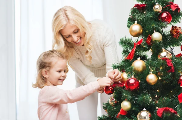 Happy family decorating christmas tree at home — Stock Photo, Image