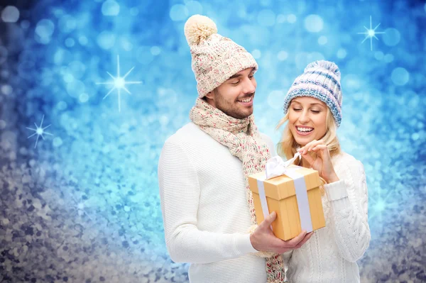 Uśmiechnięta para w zimowych ubraniach z pudełkiem prezentów — Zdjęcie stockowe