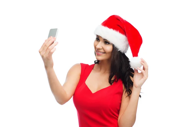 Woman in santa hat taking selfie by smartphone — Stock Photo, Image