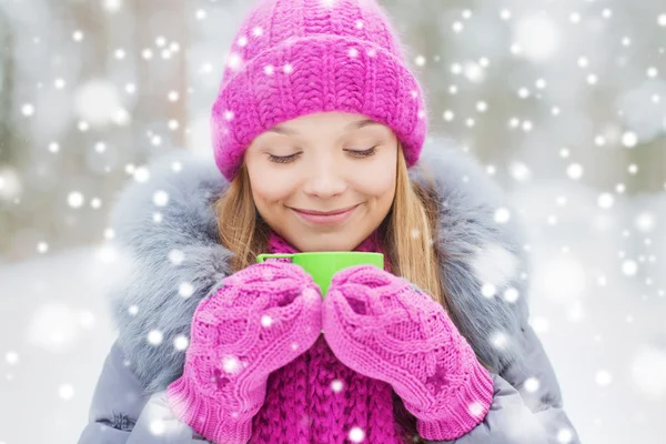 Lächelnde junge Frau mit Tasse im Winterwald — Stockfoto