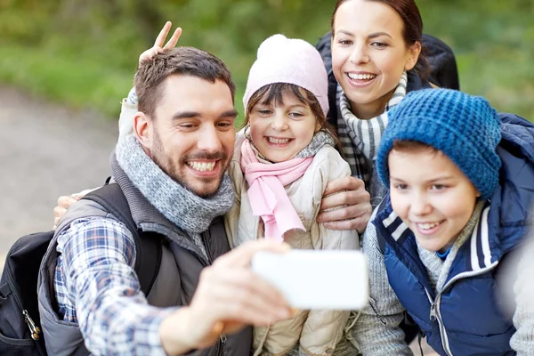 Family taking selfie with smartphone in woods — Stock Photo, Image