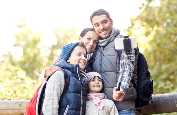Šťastná rodina s smartphone selfie stick v lese — Stock fotografie