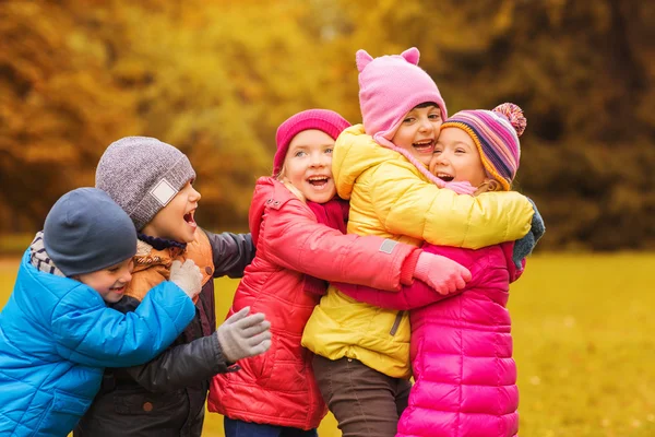 Grupo de niños felices abrazándose en el parque de otoño — Foto de Stock