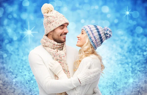 Happy couple in winter clothes hugging over lights — ストック写真