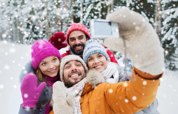 Amis souriants avec caméra dans la forêt d'hiver — Photo