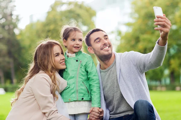 Szczęśliwa rodzina biorąc selfie przez smartphone na zewnątrz — Zdjęcie stockowe