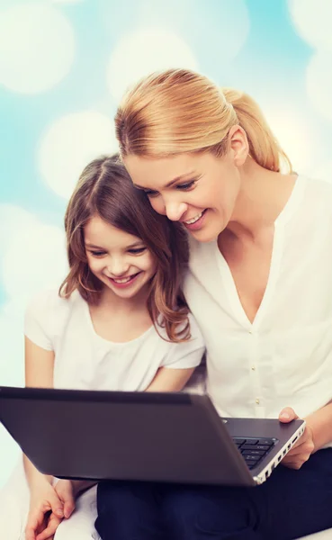 Gülümseyen anne ve dizüstü bilgisayar ile küçük kız — Stok fotoğraf