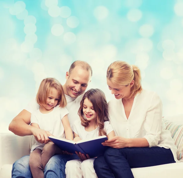 Família feliz com livro em casa — Fotografia de Stock