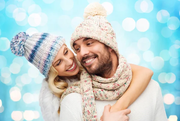 Happy couple in winter clothes hugging over lights — Stok fotoğraf