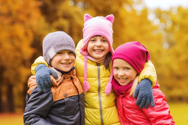 Група щасливих дітей, що обіймаються в осінньому парку — стокове фото