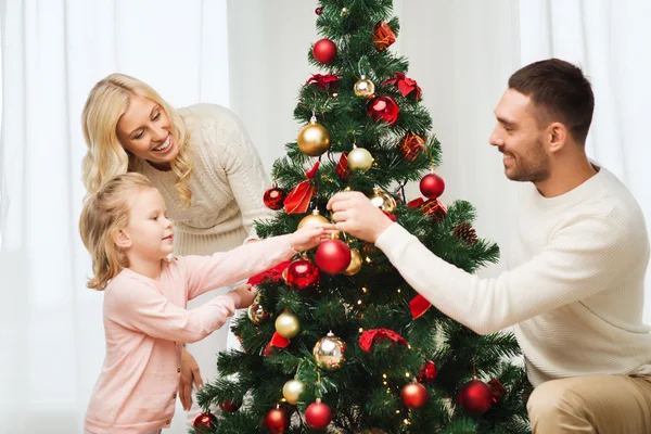 Glückliche Familie schmückt Weihnachtsbaum zu Hause — Stockfoto