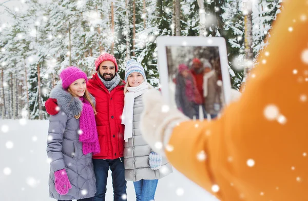 Lachende vrienden met tablet pc in winter forest — Stockfoto