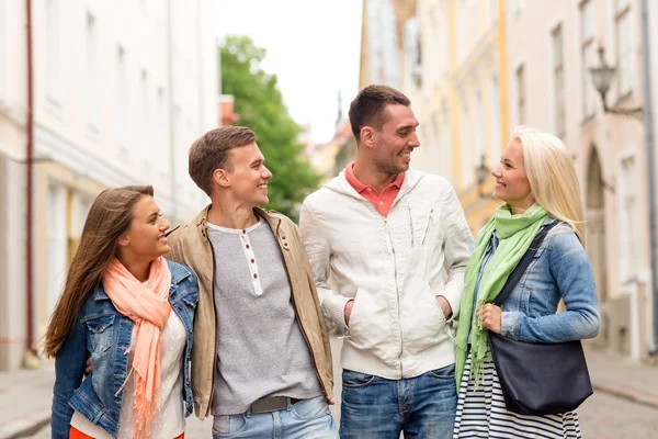 Groep lachende vrienden wandelen in de stad — Stockfoto